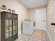 Laundry room featuring modern appliances, stylish tile floor, and a decorative storage cabinet at 2161 Gold Dust Dr, Minneola, FL 34715