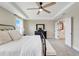 Main bedroom showcasing tray ceilings, a ceiling fan, and an en-suite bathroom at 2161 Gold Dust Dr, Minneola, FL 34715