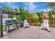 Backyard with built-in grill, seating, a brick fence, mature landscaping, and pavers at 233 Largovista Dr, Oakland, FL 34787