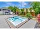 This backyard includes a modern hot tub and is surrounded by tropical landscaping at 233 Largovista Dr, Oakland, FL 34787