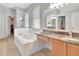 Bright bathroom featuring a soaking tub, granite vanity, and a glass shower enclosure at 233 Largovista Dr, Oakland, FL 34787