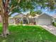 Charming one-story home with a beautiful lawn, mature trees, and well-manicured landscaping at 233 Largovista Dr, Oakland, FL 34787