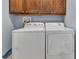 Bright laundry room features a white washer and dryer with wooden cabinets above at 233 Largovista Dr, Oakland, FL 34787