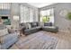 Bright living room featuring a gray sectional sofa, patterned rug, and ample natural light at 233 Largovista Dr, Oakland, FL 34787