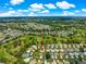 Aerial photo of home in golf course community near lush landscaping under a bright blue sky with scattered clouds at 2450 Merida Cir, The Villages, FL 32162
