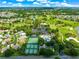 Expansive aerial view showcasing lush golf course, tennis courts, pool, and beautiful homes within the community at 2450 Merida Cir, The Villages, FL 32162