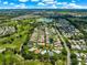Aerial view of a residential community with golf course, water feature and lush landscaping at 2450 Merida Cir, The Villages, FL 32162