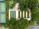 Aerial photograph of shuffleboard courts next to tennis court with beautiful landscaping and mature trees at 2450 Merida Cir, The Villages, FL 32162