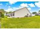 Expansive backyard with green lawn, and a view of the house's rear exterior at 2450 Merida Cir, The Villages, FL 32162