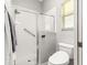 Bright bathroom features a glass shower door, grab bar, and comfort height toilet at 2450 Merida Cir, The Villages, FL 32162