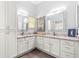 Bright bathroom boasts double sinks, granite counters, and modern lighting fixtures at 2450 Merida Cir, The Villages, FL 32162