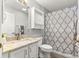 Bathroom featuring granite countertops, a mirrored cabinet, and patterned shower curtain at 2450 Merida Cir, The Villages, FL 32162