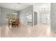 Open-concept dining area with tile flooring, a chandelier, and a view into the kitchen with white cabinets at 2450 Merida Cir, The Villages, FL 32162