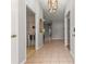 Welcoming foyer with neutral tile flooring, a decorative light fixture, and doorways leading to various rooms at 2450 Merida Cir, The Villages, FL 32162