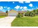 Inviting single-Gathering home featuring a well-manicured lawn and two-car garage at 2450 Merida Cir, The Villages, FL 32162