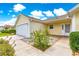 Inviting front porch with brick accents, leading to a bright yellow house with well-maintained landscaping at 2450 Merida Cir, The Villages, FL 32162