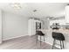 Open concept kitchen with stainless steel appliances and a breakfast bar with two modern stools at 2450 Merida Cir, The Villages, FL 32162