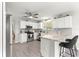 Well-lit kitchen with white cabinetry, stainless steel appliances, and a breakfast bar with modern stools at 2450 Merida Cir, The Villages, FL 32162