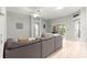 Neutral toned living room with a large sofa and access to an outdoor patio through sliding doors at 2450 Merida Cir, The Villages, FL 32162