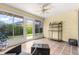 Bright sunroom with tile floors, seating, and views of the landscaped backyard at 2450 Merida Cir, The Villages, FL 32162