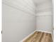 Spacious walk-in closet with white wire shelving and wood look flooring at 2450 Merida Cir, The Villages, FL 32162