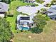 Aerial view of a screened-in pool home in a neighborhood with mature landscaping and close to a cul-de-sac at 25400 Waterbrook Ct, Leesburg, FL 34748