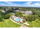 An aerial view of the neighborhood, featuring a pool, clubhouse, tennis courts, and community areas at 25400 Waterbrook Ct, Leesburg, FL 34748