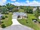 Aerial view of a single-story home with a well-manicured lawn and a circular driveway at 25400 Waterbrook Ct, Leesburg, FL 34748