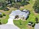 Spacious single-story home with a screened-in pool, lush landscaping, and a circular driveway at 25400 Waterbrook Ct, Leesburg, FL 34748