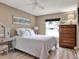 Cozy bedroom with light wood flooring, a ceiling fan, and warm neutral-toned walls at 25400 Waterbrook Ct, Leesburg, FL 34748