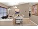 Bright dining room featuring a white table and chairs, chandelier, and neutral wall colors at 25400 Waterbrook Ct, Leesburg, FL 34748