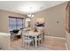 Bright dining room featuring a white table and chairs, chandelier, and neutral wall colors at 25400 Waterbrook Ct, Leesburg, FL 34748