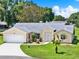 Charming home featuring a well-manicured lawn, mature landscaping, and a welcoming driveway at 25400 Waterbrook Ct, Leesburg, FL 34748