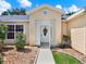 Inviting front entrance with a screened-in porch and lovely landscaping at 25400 Waterbrook Ct, Leesburg, FL 34748