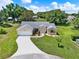 Aerial view of charming home with manicured front yard, long driveway, and mature palm tree at 25400 Waterbrook Ct, Leesburg, FL 34748