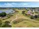 Aerial view of a scenic golf course with lush fairways, serene lakes, and manicured greens, perfect for avid golfers at 25400 Waterbrook Ct, Leesburg, FL 34748
