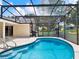 Sparkling pool in screened enclosure featuring a grill and a comfortable hanging chair at 25400 Waterbrook Ct, Leesburg, FL 34748