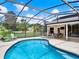 Relaxing screened-in pool with clear blue water, outdoor seating, and a covered patio at 25400 Waterbrook Ct, Leesburg, FL 34748