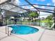 Outdoor pool area in screened enclosure featuring green seating and lush tropical landscaping at 25400 Waterbrook Ct, Leesburg, FL 34748