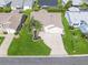 Aerial view showcases the home's manicured lawn, driveway, landscaping, and surrounding neighborhood at 2620 Persimmon Loop, The Villages, FL 32162