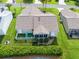 Aerial view of the home, featuring a quaint backyard seating area, lush landscaping and a well-maintained lawn at 2620 Persimmon Loop, The Villages, FL 32162