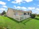 Backyard view with a white picket fence enclosing artificial turf patio seating and manicured green lawn at 2620 Persimmon Loop, The Villages, FL 32162