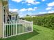 View of a cozy artificial turf patio with a white picket fence and green lawn, perfect for outdoor enjoyment at 2620 Persimmon Loop, The Villages, FL 32162