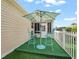 Cozy backyard patio featuring artificial turf, a charming outdoor seating set, and a shade umbrella at 2620 Persimmon Loop, The Villages, FL 32162