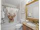 Bright bathroom featuring a granite vanity, shower with tub, and decorative floral shower curtain at 2620 Persimmon Loop, The Villages, FL 32162