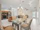Open-concept layout with kitchen, dining area, and living room with neutral colors and tile flooring at 2620 Persimmon Loop, The Villages, FL 32162