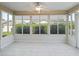 Enclosed Florida room with tile flooring and multiple windows overlooking lush greenery at 2620 Persimmon Loop, The Villages, FL 32162
