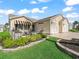 Charming home with a front porch, stone pillars, manicured landscaping, and an attached two-car garage at 2620 Persimmon Loop, The Villages, FL 32162