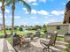 Inviting front porch with a stone base, outdoor seating, and tranquil views of the neighborhood at 2620 Persimmon Loop, The Villages, FL 32162