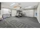Organized garage with storage cabinets, space for a golf cart, and textured carpet flooring at 2620 Persimmon Loop, The Villages, FL 32162